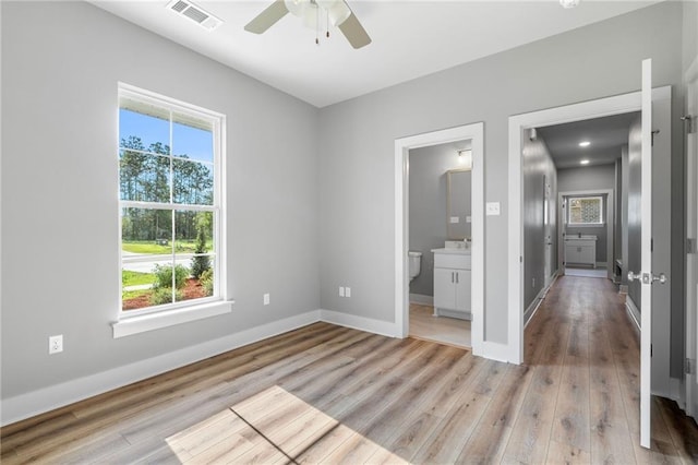 unfurnished bedroom with baseboards, visible vents, multiple windows, and light wood finished floors