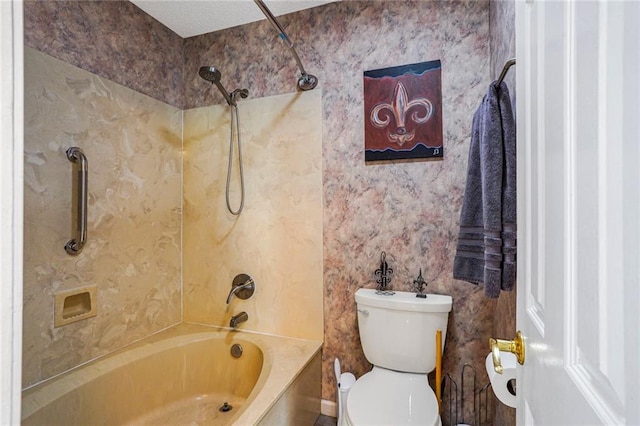 full bath featuring  shower combination, toilet, and wallpapered walls