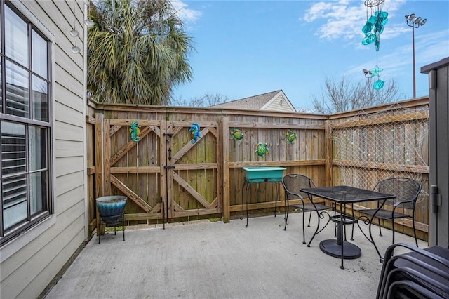 view of patio / terrace with outdoor dining space, a gate, and fence