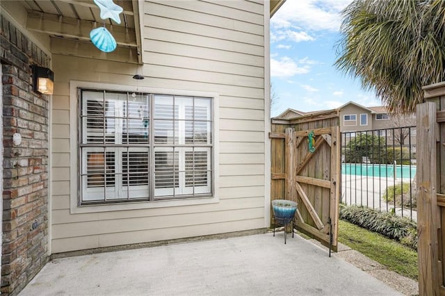 view of patio featuring fence and a gate