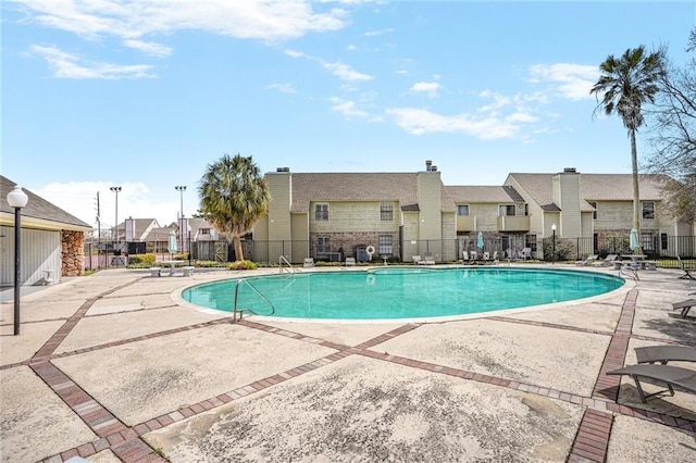 pool featuring a residential view, fence, and a patio