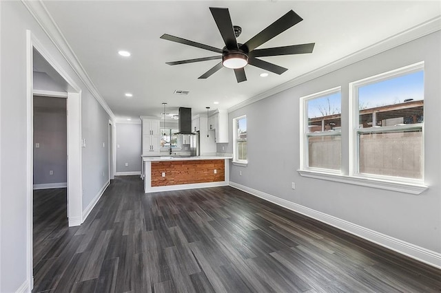 kitchen featuring light countertops, ornamental molding, exhaust hood, and baseboards