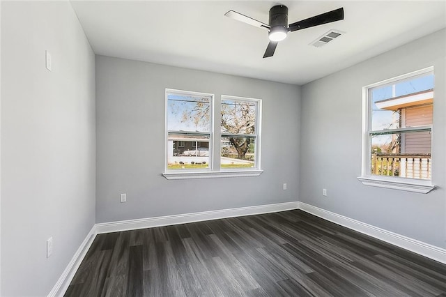 unfurnished room featuring a ceiling fan, dark wood-style flooring, visible vents, and baseboards