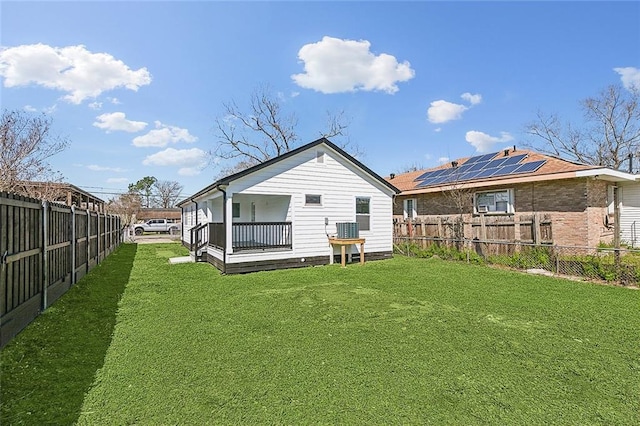 back of house with a fenced backyard and a yard