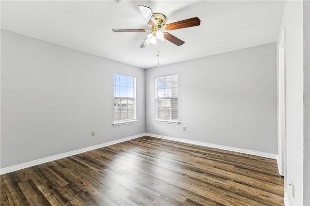 spare room featuring ceiling fan, baseboards, and dark wood-type flooring