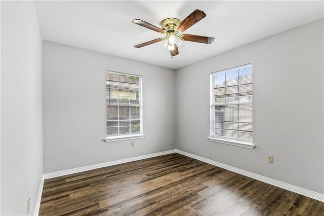 empty room featuring dark wood-style floors, a ceiling fan, and baseboards