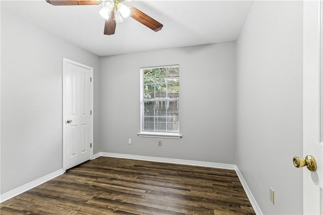 empty room with dark wood-style floors, ceiling fan, and baseboards