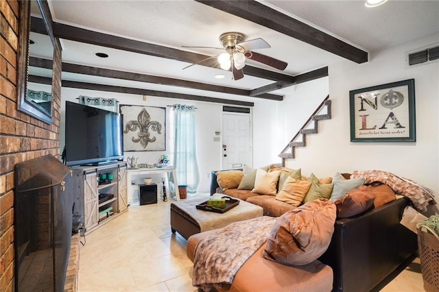 living area with ceiling fan, light tile patterned floors, visible vents, stairway, and beam ceiling