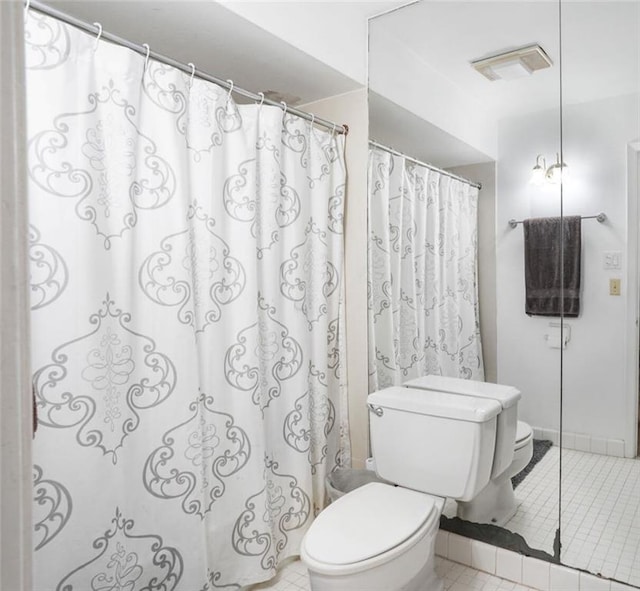 bathroom featuring a shower with shower curtain, tile patterned flooring, visible vents, and toilet