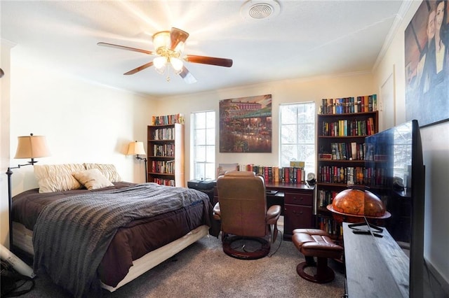 bedroom with ceiling fan, ornamental molding, carpet, and visible vents