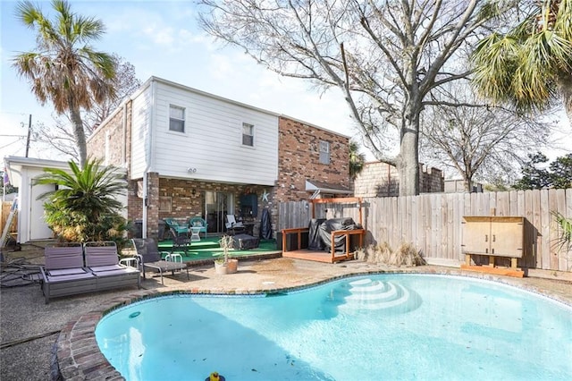 view of swimming pool featuring grilling area, a patio area, fence, and a fenced in pool