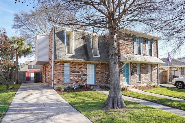 view of front facade featuring fence, a front lawn, concrete driveway, and brick siding