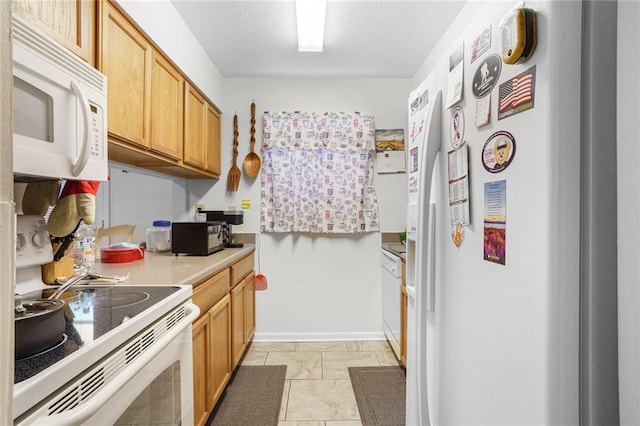 kitchen with a textured ceiling, light countertops, white appliances, and baseboards