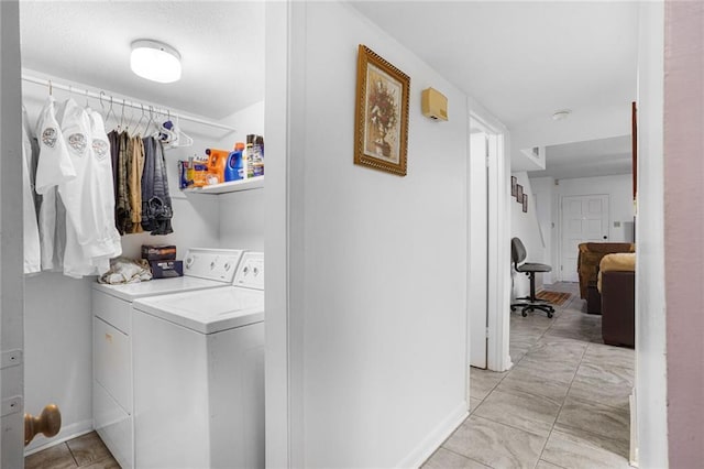 washroom with laundry area, washing machine and clothes dryer, and baseboards