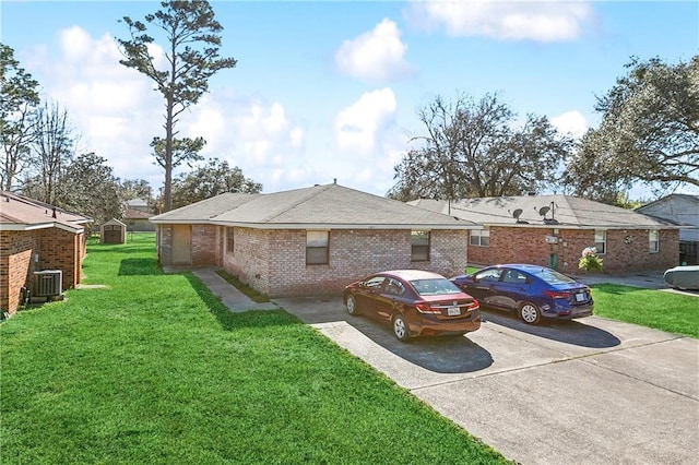 view of front facade featuring brick siding, a front yard, and central air condition unit