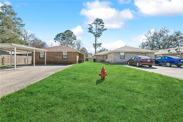 view of yard with driveway and fence