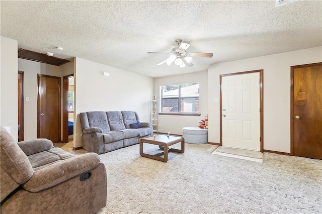 carpeted living area with ceiling fan, baseboards, and a textured ceiling