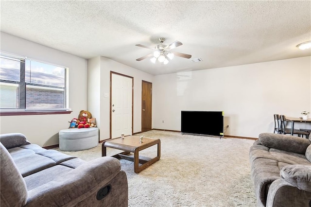 living room with a ceiling fan, light colored carpet, a textured ceiling, and baseboards