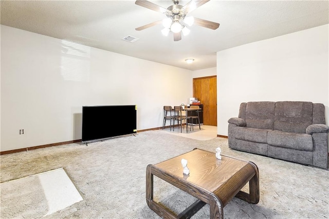 living room with ceiling fan, carpet floors, visible vents, and baseboards