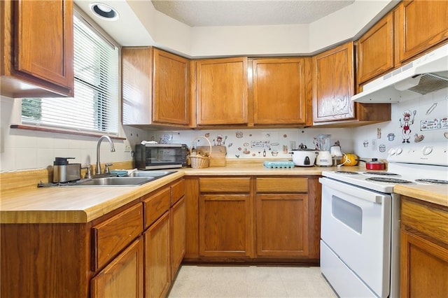 kitchen with under cabinet range hood, white electric stove, light countertops, and a sink