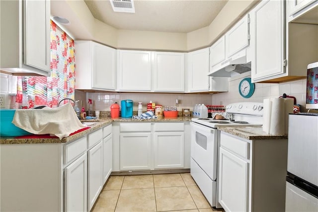 kitchen featuring light tile patterned flooring, under cabinet range hood, visible vents, electric stove, and tasteful backsplash