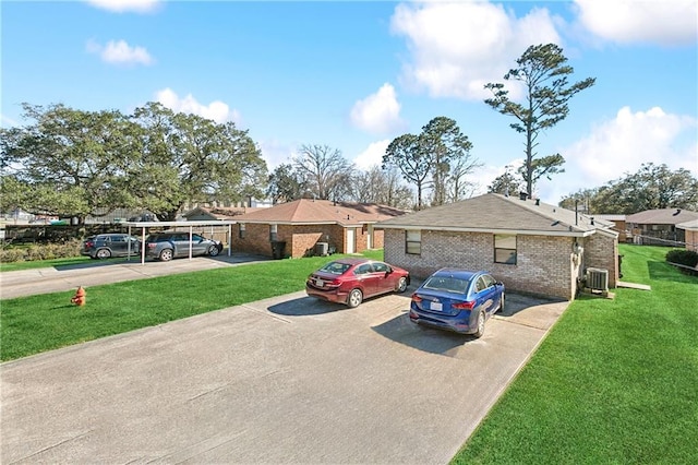 ranch-style home featuring central AC unit, a front lawn, and brick siding