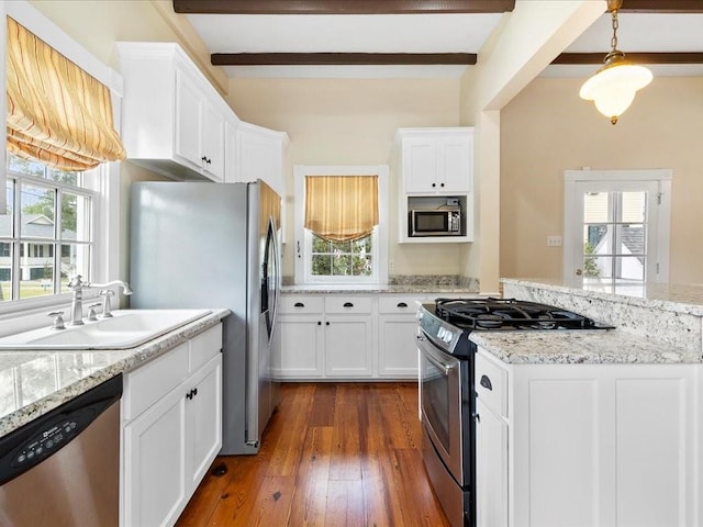 kitchen with white cabinets, dark wood-type flooring, a sink, stainless steel appliances, and beam ceiling