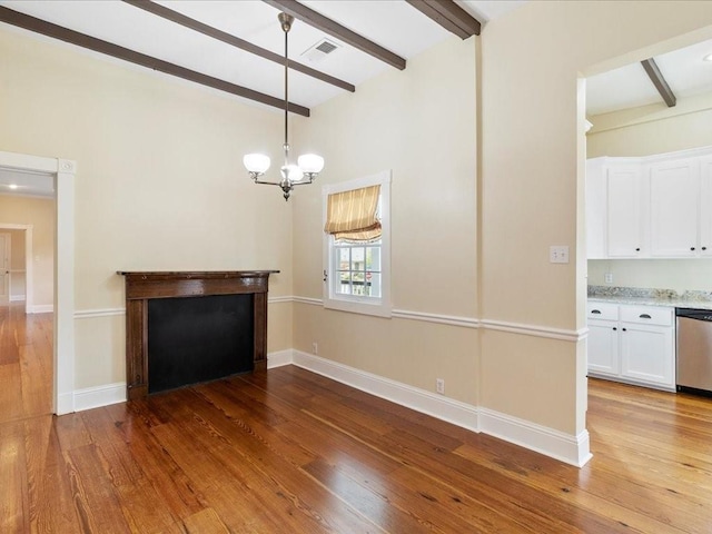 unfurnished living room with hardwood / wood-style flooring, visible vents, and beam ceiling