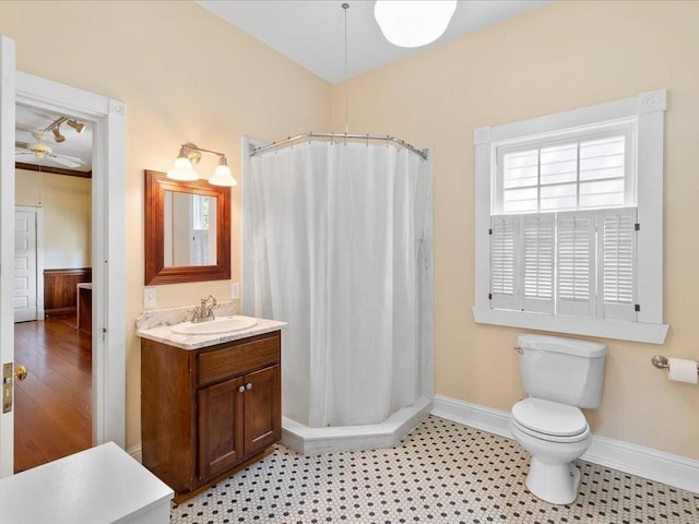 bathroom with baseboards, toilet, vanity, and a shower with shower curtain