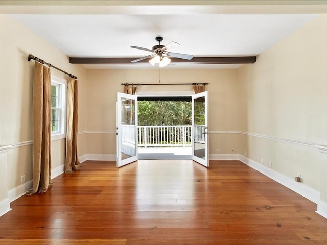 unfurnished room featuring plenty of natural light, beamed ceiling, and wood finished floors