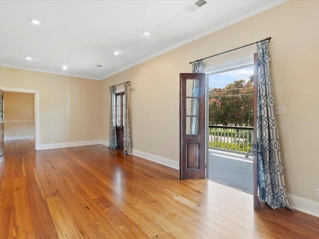 spare room with baseboards, visible vents, crown molding, light wood-style floors, and recessed lighting