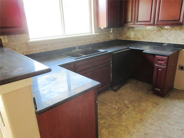 kitchen featuring reddish brown cabinets, a peninsula, a sink, and decorative backsplash