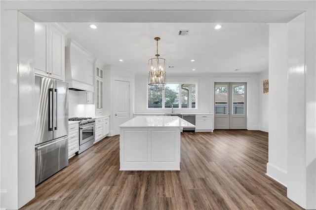 kitchen featuring premium range hood, high quality appliances, white cabinets, light countertops, and glass insert cabinets