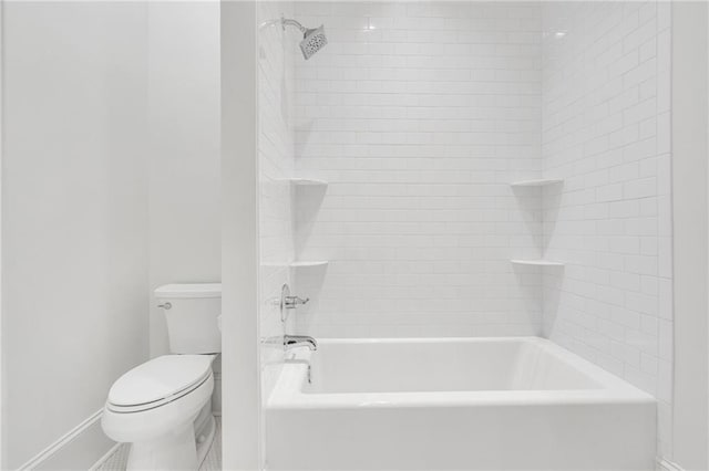 bathroom featuring baseboards, shower / tub combination, and toilet