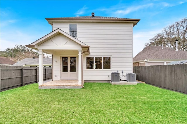 back of house featuring a fenced backyard, a lawn, a patio, and central air condition unit