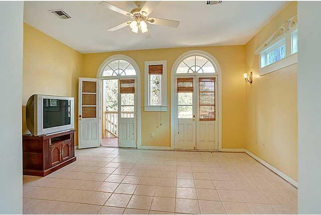 foyer featuring light tile patterned floors, a ceiling fan, visible vents, and a healthy amount of sunlight