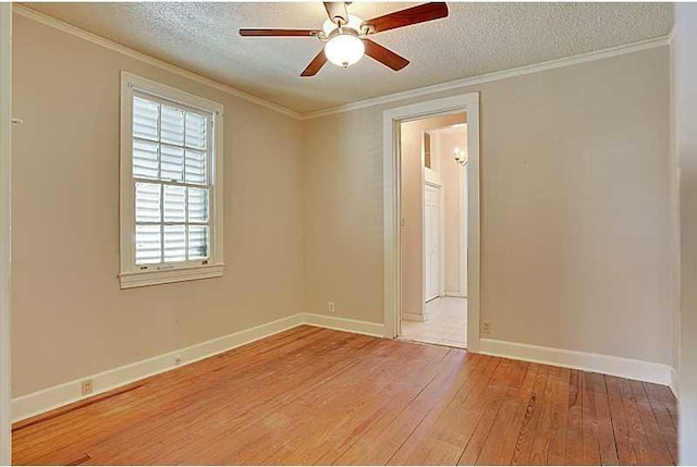 spare room with a textured ceiling, a ceiling fan, baseboards, light wood finished floors, and crown molding