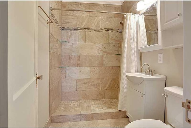 full bathroom with tiled shower, vanity, and toilet