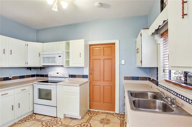 kitchen with white appliances, light tile patterned floors, white cabinetry, and a sink