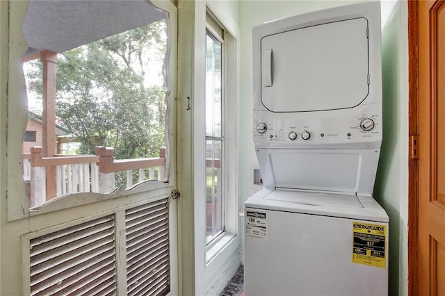 washroom with stacked washer and clothes dryer and laundry area