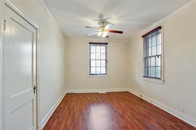 empty room featuring baseboards, ornamental molding, dark wood finished floors, and a ceiling fan