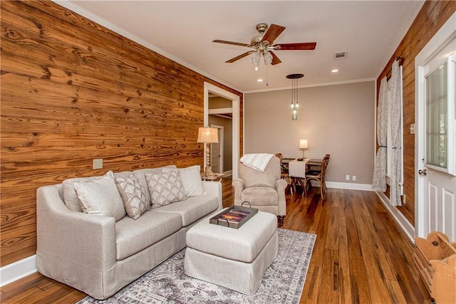 living room featuring baseboards, visible vents, ceiling fan, hardwood / wood-style floors, and crown molding