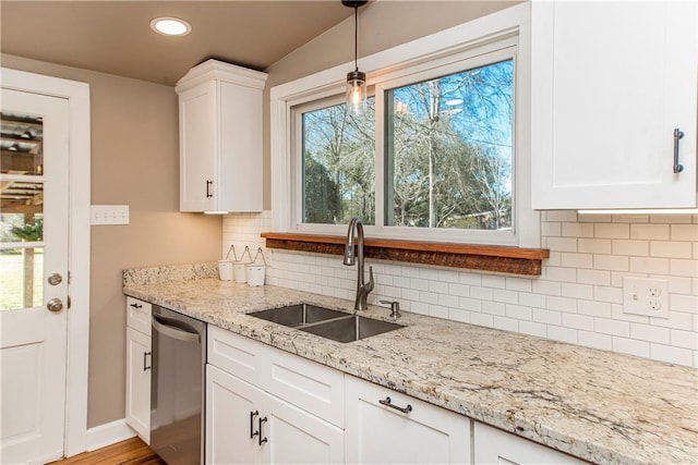 kitchen featuring tasteful backsplash, dishwasher, light stone counters, white cabinetry, and a sink