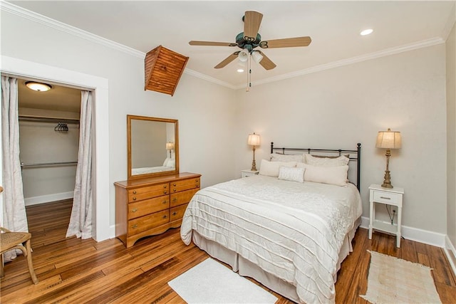 bedroom featuring recessed lighting, wood finished floors, baseboards, ornamental molding, and a closet