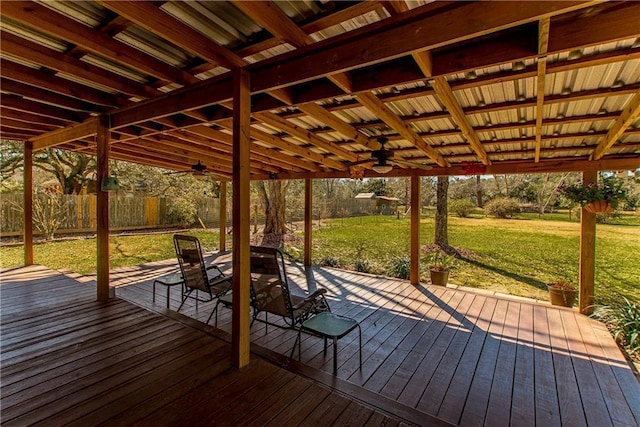 deck with ceiling fan, fence, and a yard