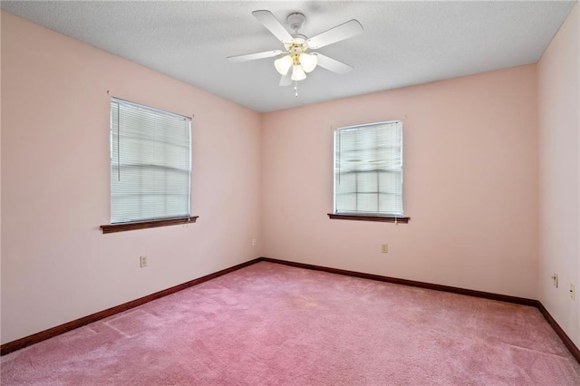 spare room featuring carpet, baseboards, ceiling fan, and a textured ceiling