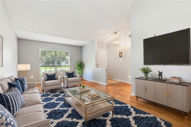 living area with light wood-style floors, lofted ceiling, a notable chandelier, and baseboards