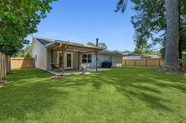 back of house featuring a fenced backyard, a patio, and a lawn