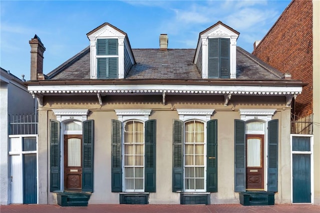 exterior space with a chimney and stucco siding