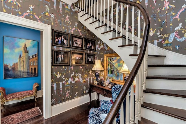 stairway featuring baseboards, wood finished floors, and wallpapered walls